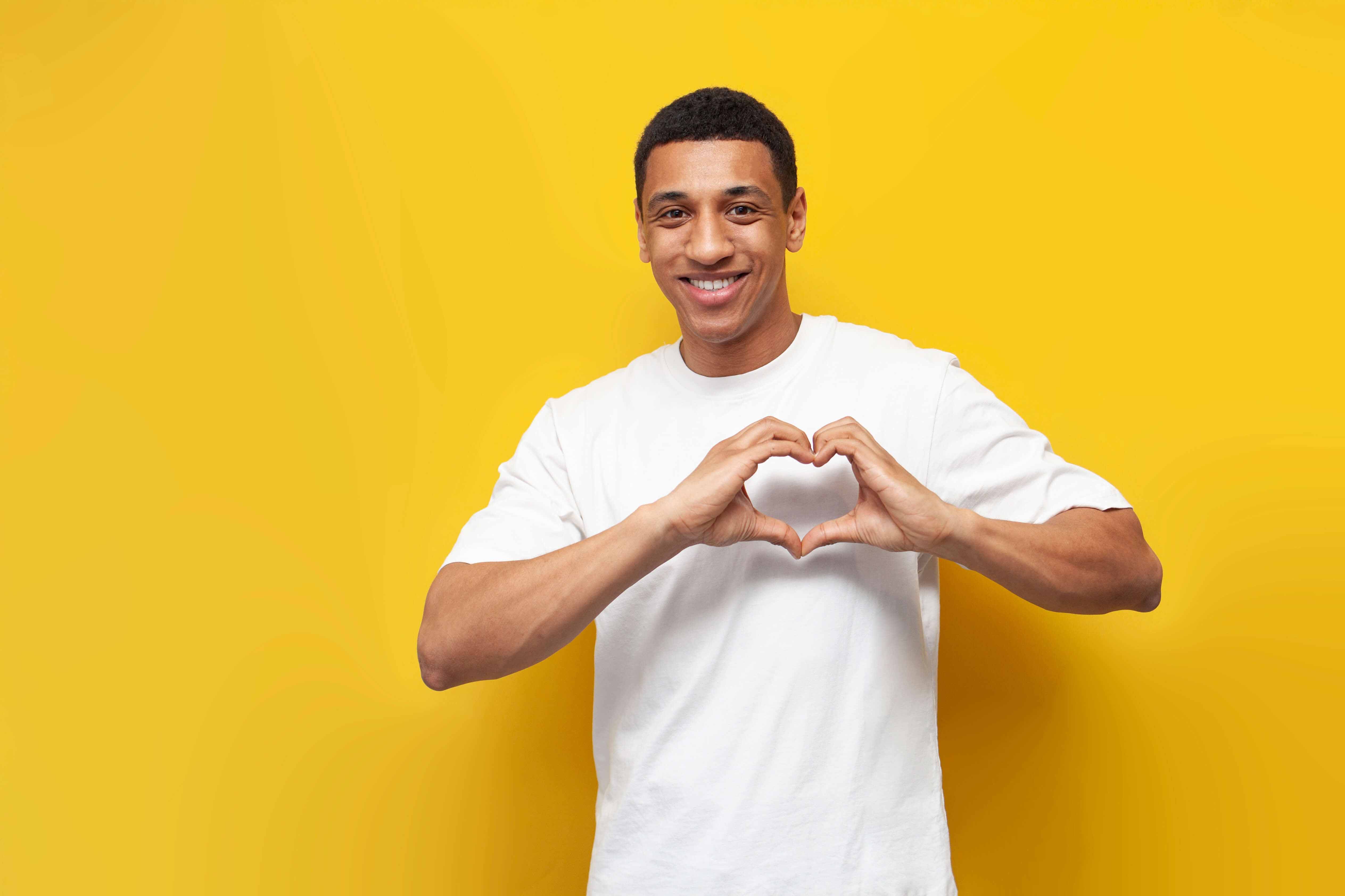 A man making the shape of a heart with his hands