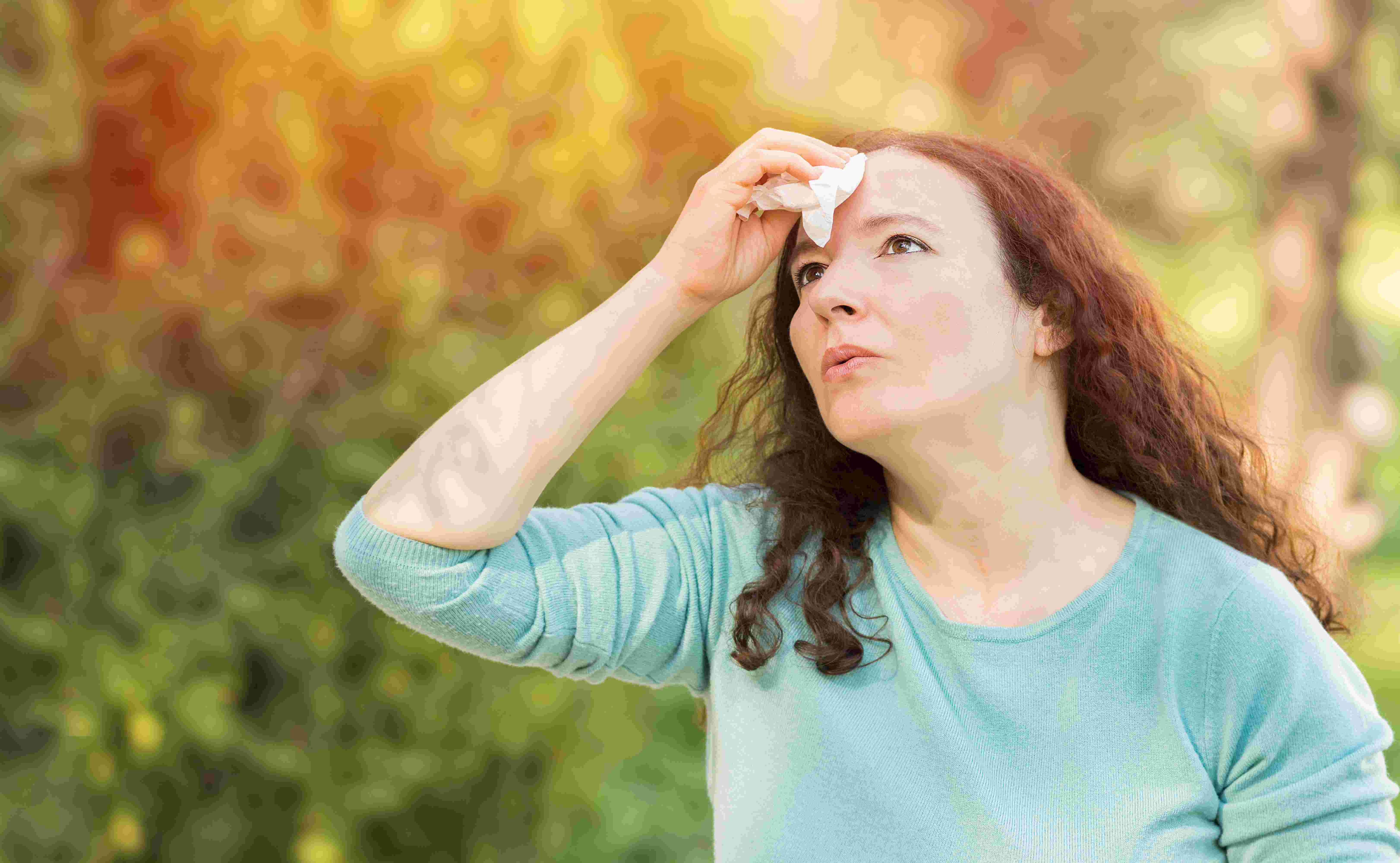 woman dabs forehead in hot sun