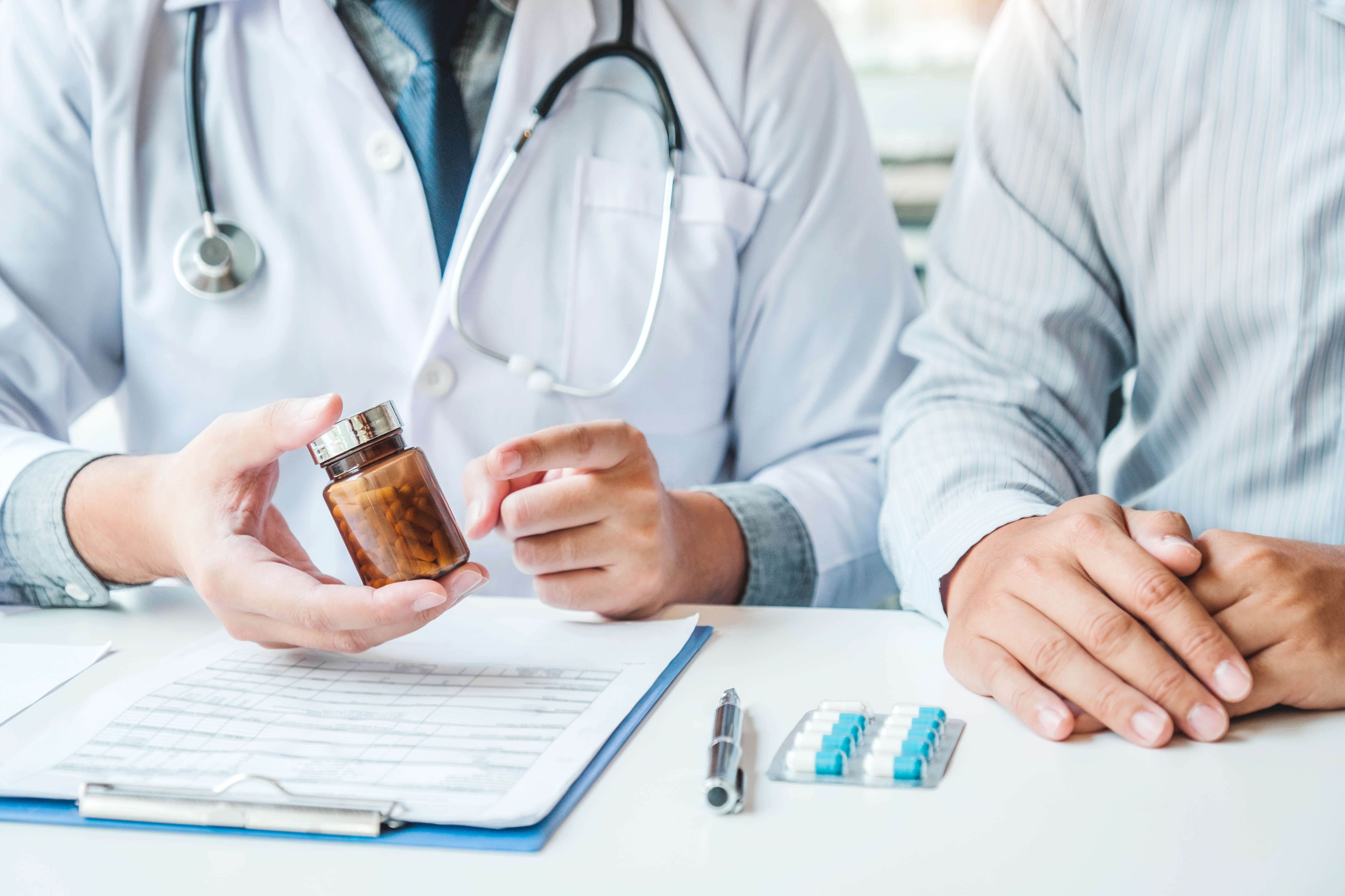 Doctor or physician recommend pills medical prescription to male Patient hospital and medicine concept
