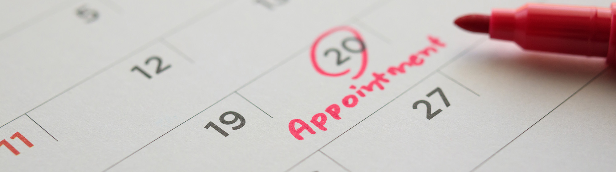 Calendar with a red marker and a date circled with the word appointment written underneath.