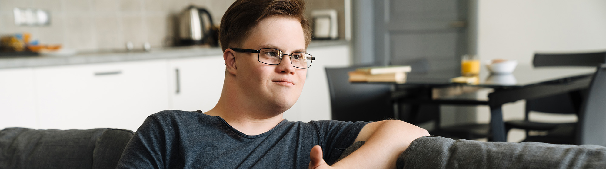 Teenager sitting on couch having a discussion with someone not in the photo.