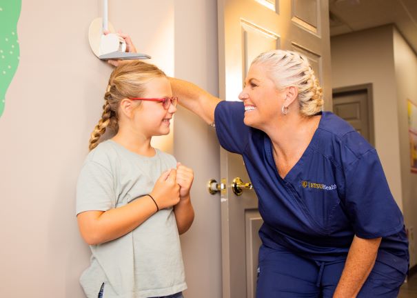 Nurse measuring child's height