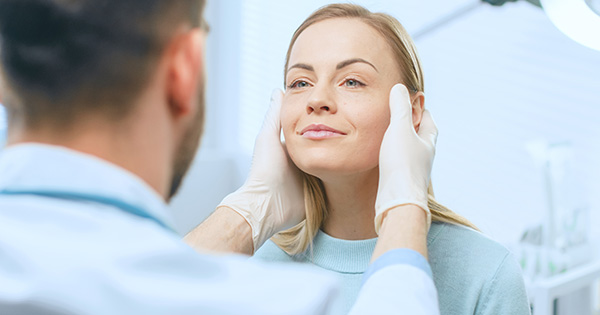 Provider examining woman's face.