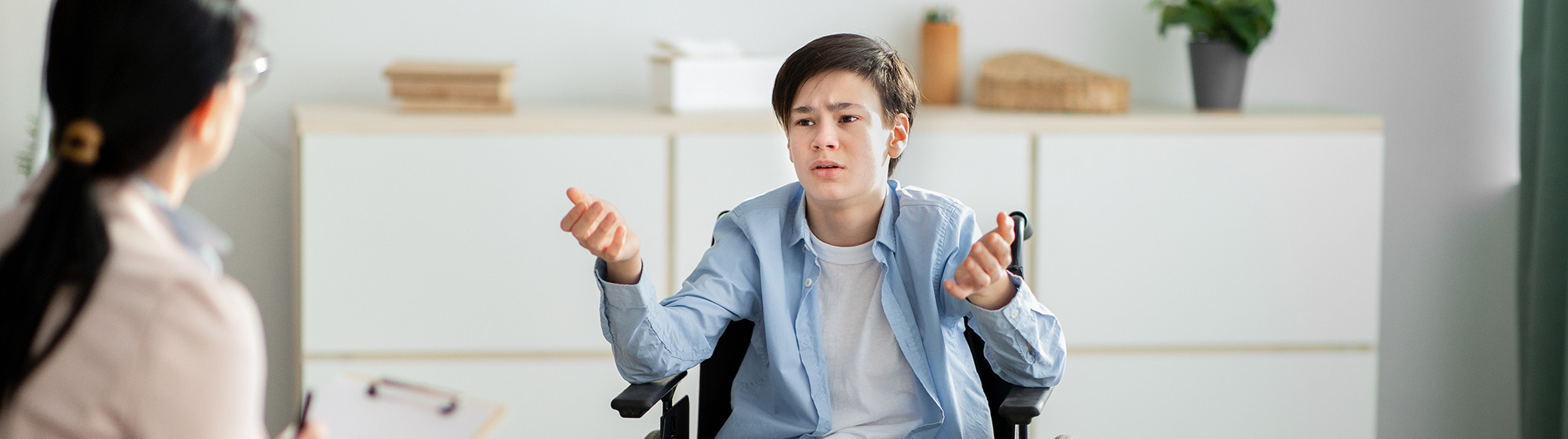 Teenager in a wheelchair talking to a providers.