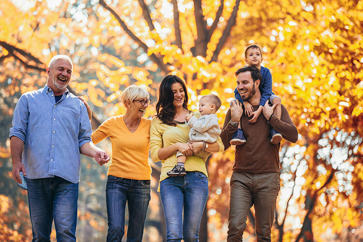 Family walking on path with fall leaves 